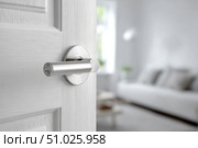 Doorknob. Metal door handle lock and latch of brass on veneer doors. Door wooden half opening through interior bedroom background, selective focus. Modern trends in interior design. Close-up. Стоковое AI-изображение, AI-художник Марина Демидюк / Фотобанк Лори