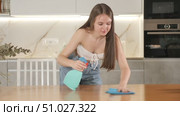 In kitchen, positive housewife in casual clothes holds rag in hands and cleans surface of table. Стоковое видео, видеограф Яков Филимонов / Фотобанк Лори