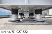 Spring vibration isolators supporting industrial hvac unit on rooftop. Стоковое AI-изображение, AI-художник Юрий Поздников / Фотобанк Лори