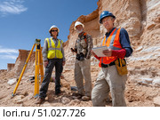 Team of geologists conducting field research using surveying equipment and digital tablet. Стоковое AI-изображение, AI-художник Юрий Поздников / Фотобанк Лори