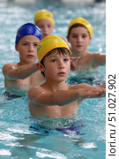 Children learning synchronized swimming in indoor pool. Стоковое AI-изображение, AI-художник Юрий Поздников / Фотобанк Лори