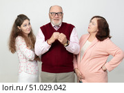 A photo of a father being looked at reproachfully by an adult daughter and wife. Стоковое фото, фотограф Лазаренко Светлана / Фотобанк Лори