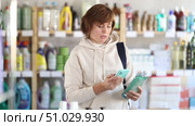 Woman housewife store visitor examines product, scans barcode to check product in quality control system. Client gets acquainted with information about dishwashing soap gel product. Стоковое видео, видеограф Яков Филимонов / Фотобанк Лори
