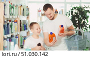 Schoolboy son and dad are choosing unclogging agent in store. Стоковое видео, видеограф Яков Филимонов / Фотобанк Лори