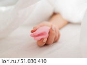 A faceless woman lies in bed under a blanket holding a clitoral vibrator. The girl masturbates. Стоковое фото, фотограф Михаил Решетников / Фотобанк Лори