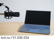Close-up of a professional microphone on the background of a laptop. Radio broadcaster's desktop. Стоковое фото, фотограф Михаил Решетников / Фотобанк Лори