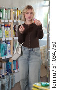 Girl housewife in household store examines goods, chooses nail polish. Стоковое видео, видеограф Яков Филимонов / Фотобанк Лори