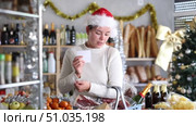 Feale customer prepares to celebrate Christmas - they buy food and alcohol according to checklist at the supermarket. Стоковое видео, видеограф Яков Филимонов / Фотобанк Лори