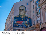 Large wall graffiti in Moscow with a portrait of Soviet commander Georgy Zhukov, made on the facade of a residential building. Zhukov is depicted in a ceremonial military uniform with numerous orders and medals. Bright and detailed street art is dedicated to the memory of the outstanding marshal of the Great Patriotic War. (2018 год). Стоковое фото, фотограф Анна Кривицкая / Фотобанк Лори