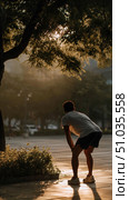 Man enjoying sunset view while taking a break in a park during golden hour. Стоковое AI-изображение, AI-художник Сергей Толмачёв / Фотобанк Лори