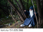 A wizard with a long gray beard and a cloak in a deep forest. An elderly man in a witcher costume. Стоковое фото, фотограф Михаил Решетников / Фотобанк Лори