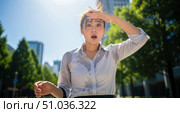 Climate change concept with shocked asian woman suffering from heatwave in city, exhausted businesswoman sweating in hot summer weather for global warming theme background. Стоковое фото, фотограф Павел Муравьев / Фотобанк Лори