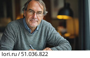 An older man sits at a desk, deeply engaged in writing notes while enjoying the warm ambiance of a cozy room filled with soft lighting. Стоковое AI-видео, аниматор Данила Большаков / Фотобанк Лори