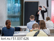 Speaker addressing audience during business seminar with attendees in focus. Стоковое фото, фотограф Антон Гвоздиков / Фотобанк Лори