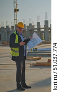 Construction Site Supervisor Reviewing Plans with Tablet and Documents Under Bright Sky Amidst Ongoing Structural Development Efforts. Стоковое AI-видео, аниматор Владимир Федоров / Фотобанк Лори