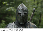 Medieval knight wearing helmet and armor in forest setting. Стоковое AI-изображение, AI-художник Иван Рябоконь / Фотобанк Лори