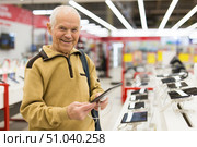 senor man pensioner buying modern tablet digital in showroom of digital electronic goods store. Стоковое фото, фотограф Татьяна Яцевич / Фотобанк Лори