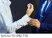Male hands putting cufflinks on the sleeves of a man. Стоковое фото, фотограф Наталия Кирсанова / Фотобанк Лори