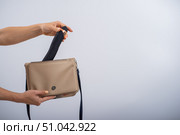 A woman puts a dildo in a handbag on a white background. Close-up of female hands with a black vibrator. Стоковое фото, фотограф Михаил Решетников / Фотобанк Лори