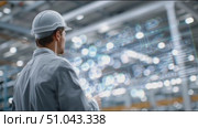 Worker observes production process in a modern facility during working hours. Стоковое AI-видео, аниматор Сергей Толмачёв / Фотобанк Лори