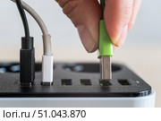 Modern convenient multi-port usb charger for devices. Close-up of a female hand plugging multi-colored cables into a power outlet. Macro. Стоковое фото, фотограф Михаил Решетников / Фотобанк Лори