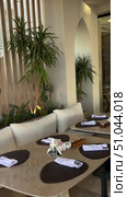 Luxury Arabian resort Empty tables and chairs along white buildings Round tables and chairs at an open-air restaurant An empty cafe, restaurant terrace in an urban environment midst lush vegetation greenery. Seating, vintage tables and chairs served for guests. Luxurious reception table Tableware on tablecloths.Interior of restaurant with orange chairs, tables, brick walls. Empty eatery features bar counter, loft design, modern lighting, large windows. Cafe is ready to serve food, beverages for clients. Стоковое видео, видеограф Zita Khasanova / Фотобанк Лори