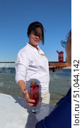 Официантка на открытой террасе подает коктейль Young smiling waitress serving cocktail to customer at outdoor cafe Smiling waitress serving food and drinks to customers having fun at restaurant Woman waiter with tray serves cocktails to multiracial women in outdoor tropical restaurant. Female hand takes glasses with alcohol drinks from puts them onto table of calisthenic smiling females. Редакционное видео, видеограф Zita Khasanova / Фотобанк Лори