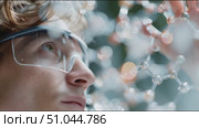 Young scientist examines molecular structure in laboratory setting with modern technology. Стоковое AI-видео, аниматор Сергей Толмачёв / Фотобанк Лори