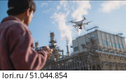 Drone operation over industrial site in sunny weather with a technician controlling from a distance. Стоковое AI-видео, аниматор Сергей Толмачёв / Фотобанк Лори