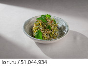 Traditional Korean side dish made from blanched soybean sprouts, sesame oil, garlic and fresh cilantro, served in a rustic ceramic bowl. Стоковое фото, фотограф Aleksandr Gavrilychev / Фотобанк Лори