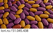 Close up view of purple and golden colored hard coated candy. Sweet chocolate dragee used as confection or snack. Стоковое AI-изображение, AI-художник Анжелика Самсонова / Фотобанк Лори
