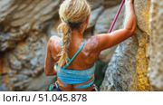 A climber gets ready to tackle a steep rock face surrounded by rugged canyon walls illuminated by sunlight, highlighting her focused determination. Стоковое AI-видео, аниматор Данила Большаков / Фотобанк Лори