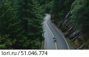 Rider experiences thrilling curves on a scenic mountain road surrounded by forests. Стоковое AI-видео, аниматор Сергей Толмачёв / Фотобанк Лори