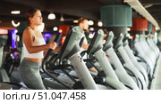 Young athletic woman in sportswear training on elliptical machine in gym. Стоковое видео, видеограф Яков Филимонов / Фотобанк Лори