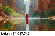 A lone kayaker glides across a calm river, flanked by towering red cliffs, as the setting sun bathes the canyon in a warm glow. Стоковое AI-видео, аниматор Данила Большаков / Фотобанк Лори