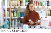Positive young female customer choosing different cosmetics in large department store. Стоковое видео, видеограф Яков Филимонов / Фотобанк Лори