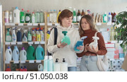 Women housewife buyers inspects product, selects multisurface cleaner spray, assembles cleaning kit. Client see over good in household shop. Стоковое видео, видеограф Яков Филимонов / Фотобанк Лори