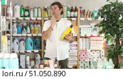 Man choose product and doubts, faultfinding buyer pick parquet polish agent for allergy sufferers and delicate skin. Customer in self-service store of supermarket, buys product. Стоковое видео, видеограф Яков Филимонов / Фотобанк Лори