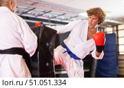 Middle‑aged man practicing kick on shield in karate dojo. Стоковое фото, фотограф Яков Филимонов / Фотобанк Лори