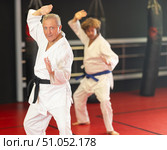 Elderly black‑belt practicing kata in dojo. Стоковое фото, фотограф Яков Филимонов / Фотобанк Лори