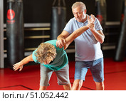 Male pupil clash with training manager during self-defense lesson, repulse charge, intensity of practice. Стоковое фото, фотограф Яков Филимонов / Фотобанк Лори