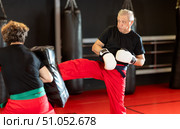Senior man firing front kick at shield during Krav Maga drill. Стоковое фото, фотограф Яков Филимонов / Фотобанк Лори