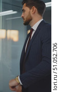 Business executive in tailored suit waits anxiously in bluish-lit office with panoramic urban view at dusk. Стоковое AI-видео, аниматор Владимир Федоров / Фотобанк Лори