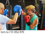 Middle‑aged man practicing punches on mitts with partner. Стоковое фото, фотограф Яков Филимонов / Фотобанк Лори