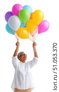 Elderly woman joyfully holding colorful balloons, celebrating happiness. Стоковое AI-изображение, AI-художник Olga Didraga / Фотобанк Лори
