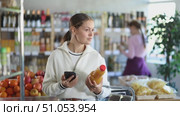 Woman scans the barcode of peach juice on her phone. Стоковое видео, видеограф Яков Филимонов / Фотобанк Лори