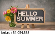 A sign with the words hello summer placed next to a colorful vase of flowers, showcasing the vibrant colors and cheerful spirit of the season. Стоковое AI-видео, аниматор Данила Большаков / Фотобанк Лори
