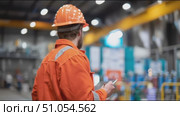Worker in safety gear conducts inspection in industrial setting during daytime. Стоковое AI-видео, аниматор Сергей Толмачёв / Фотобанк Лори