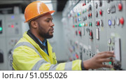 Worker operates control panel at industrial facility during daytime shift in a busy urban area. Стоковое AI-видео, аниматор Сергей Толмачёв / Фотобанк Лори