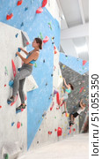 Young woman in sportswear practicing rock climbing on climbing wall. Стоковое видео, видеограф Яков Филимонов / Фотобанк Лори